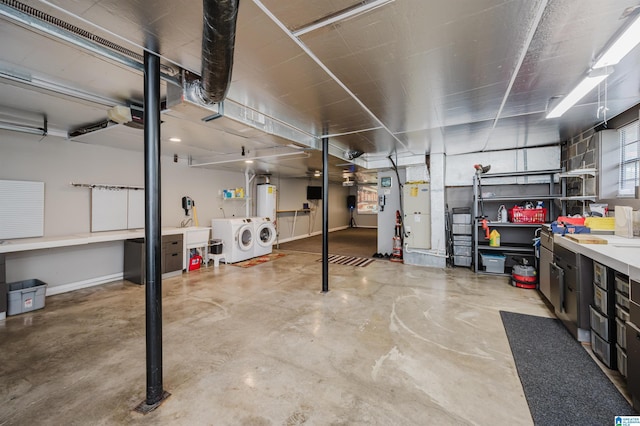 basement with baseboards, a workshop area, and washing machine and clothes dryer