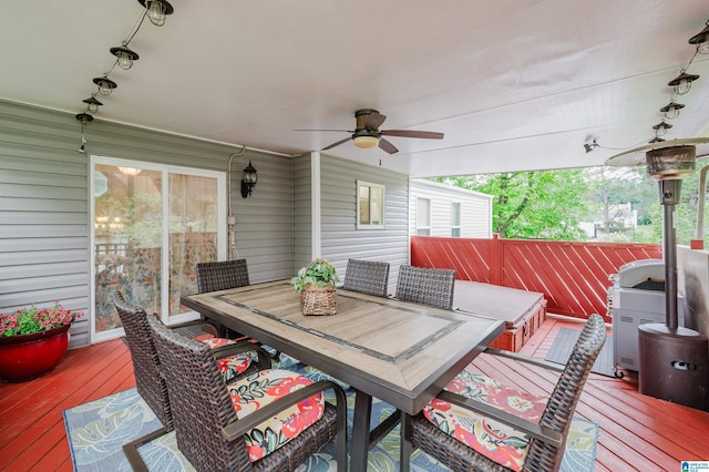wooden terrace featuring area for grilling, ceiling fan, fence, and outdoor dining area