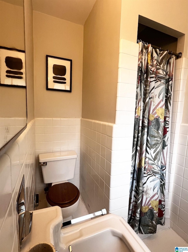 708 Devon Dr, Birmingham, AL 35209 - full bathroom with tile walls, toilet, a shower with curtain, and wainscoting