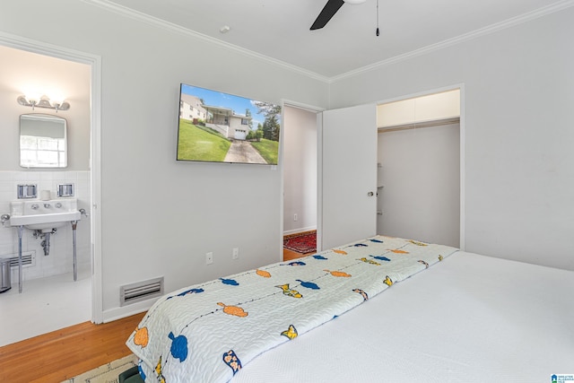 708 Devon Dr, Birmingham, AL 35209 - bedroom featuring wood finished floors, crown molding, ensuite bathroom, a ceiling fan, and a closet