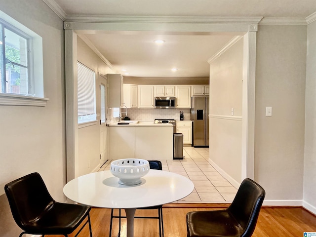 708 Devon Dr, Birmingham, AL 35209 - dining area featuring light wood finished floors, crown molding, and baseboards