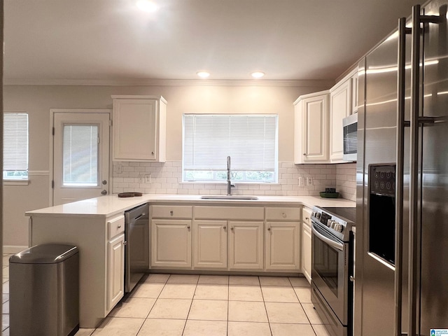 708 Devon Dr, Birmingham, AL 35209 - kitchen with appliances with stainless steel finishes, a sink, a peninsula, healthy amount of natural light, and ornamental molding