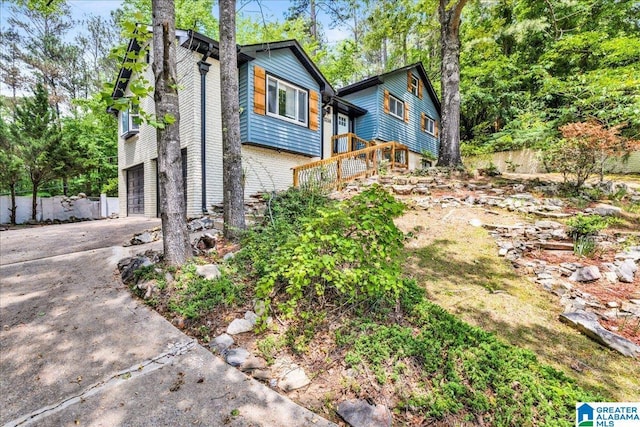 view of property exterior featuring a garage and concrete driveway
