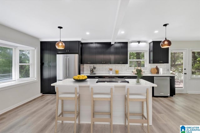 kitchen with dark cabinets, light countertops, decorative backsplash, and stainless steel appliances