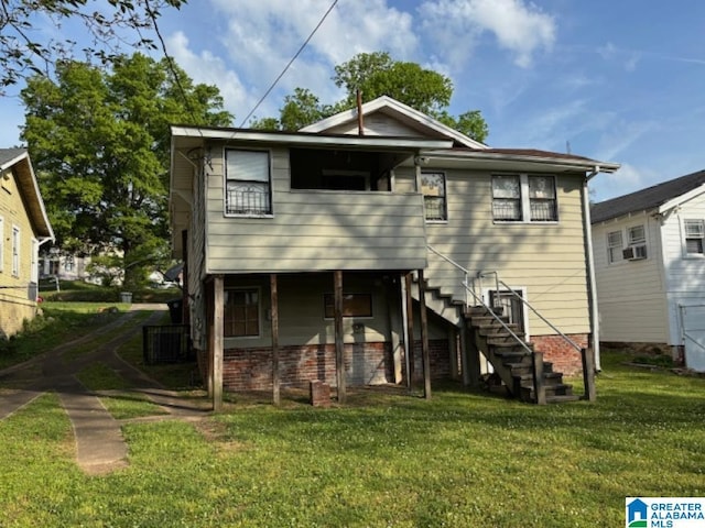 back of property featuring a yard and stairs