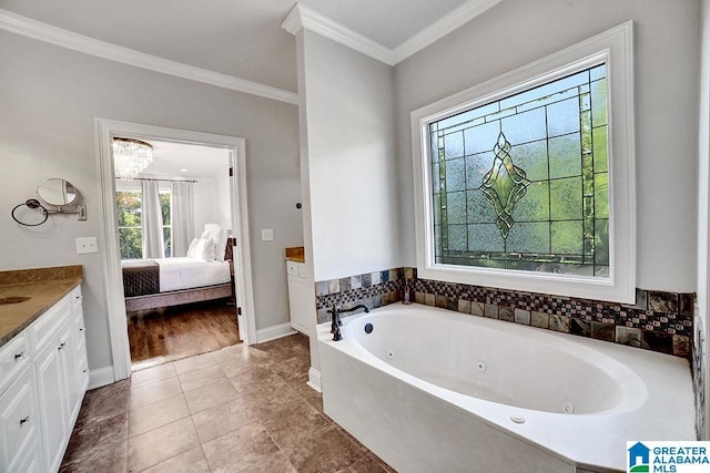 ensuite bathroom with crown molding, a tub with jets, vanity, baseboards, and ensuite bath