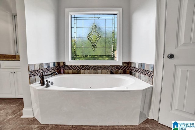 full bathroom featuring tile patterned flooring, a bath, and vanity
