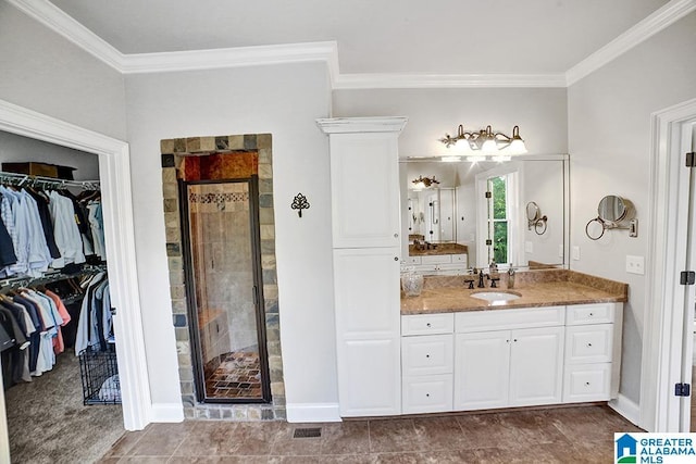 bathroom with vanity, ornamental molding, a spacious closet, and a shower stall