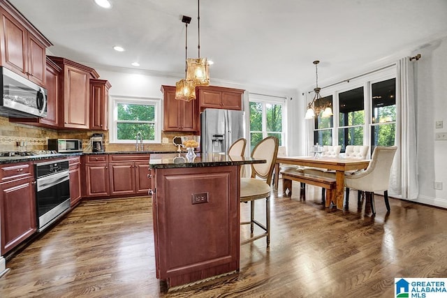 kitchen featuring stainless steel appliances, plenty of natural light, a kitchen breakfast bar, and a center island