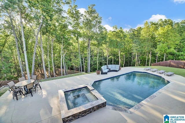 view of pool featuring a pool with connected hot tub, fence, an outdoor hangout area, and a patio area