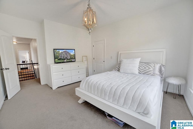 bedroom with light carpet and a notable chandelier