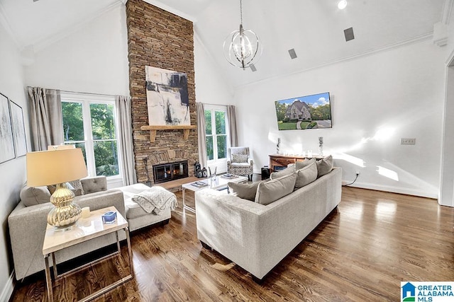 living room featuring high vaulted ceiling, a chandelier, a stone fireplace, and a wealth of natural light