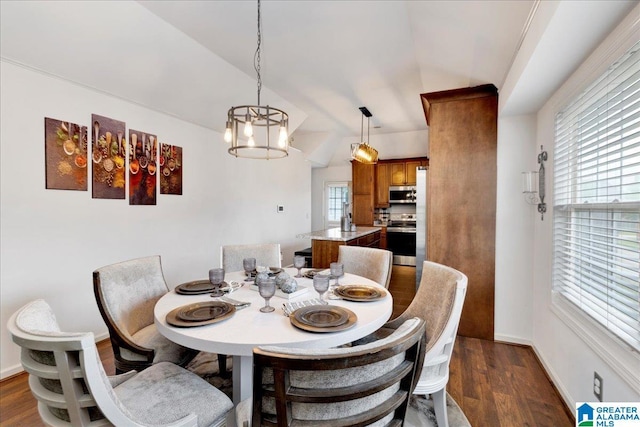 dining area featuring vaulted ceiling and dark wood-style floors