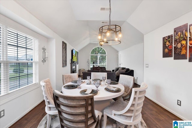 dining space featuring an inviting chandelier, dark wood-type flooring, lofted ceiling, and visible vents