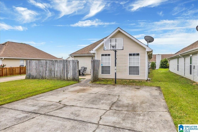 rear view of property with a lawn, a patio, and fence