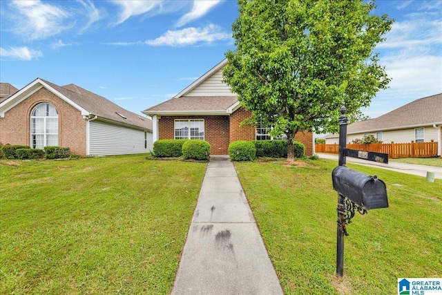 view of front of home featuring fence, a front lawn, and brick siding