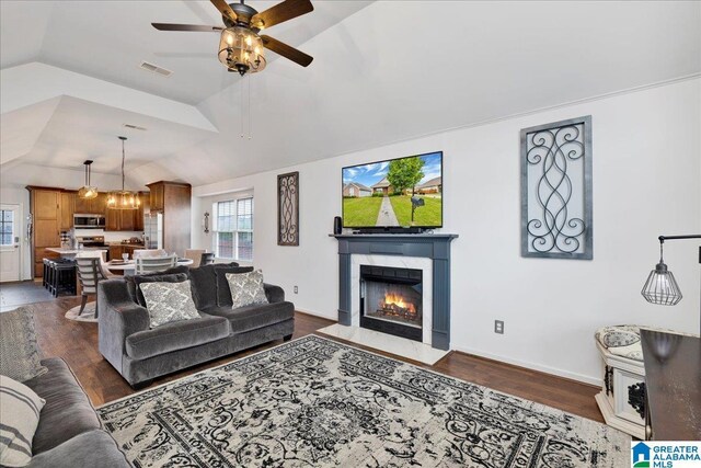living area featuring a ceiling fan, visible vents, a fireplace, dark wood finished floors, and lofted ceiling