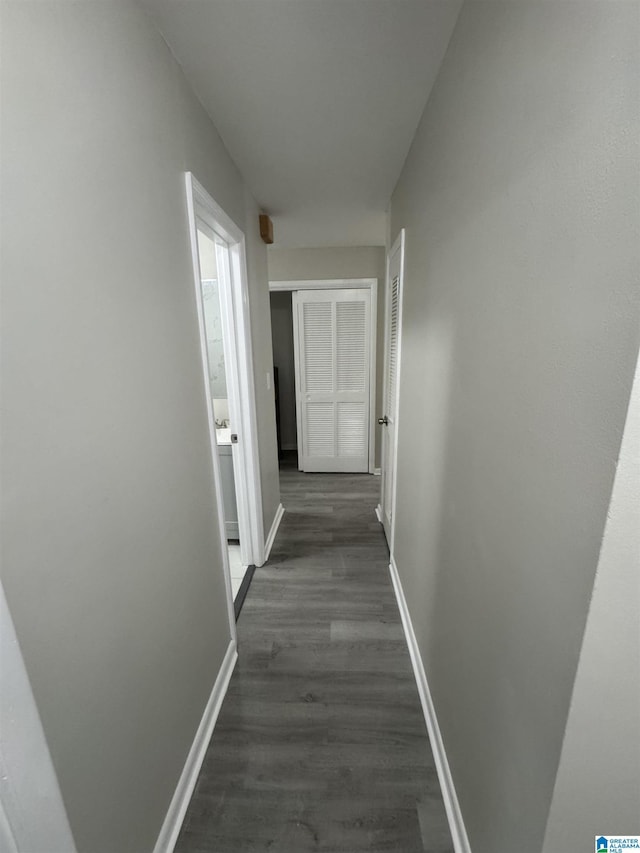 hallway with baseboards and dark wood-style floors