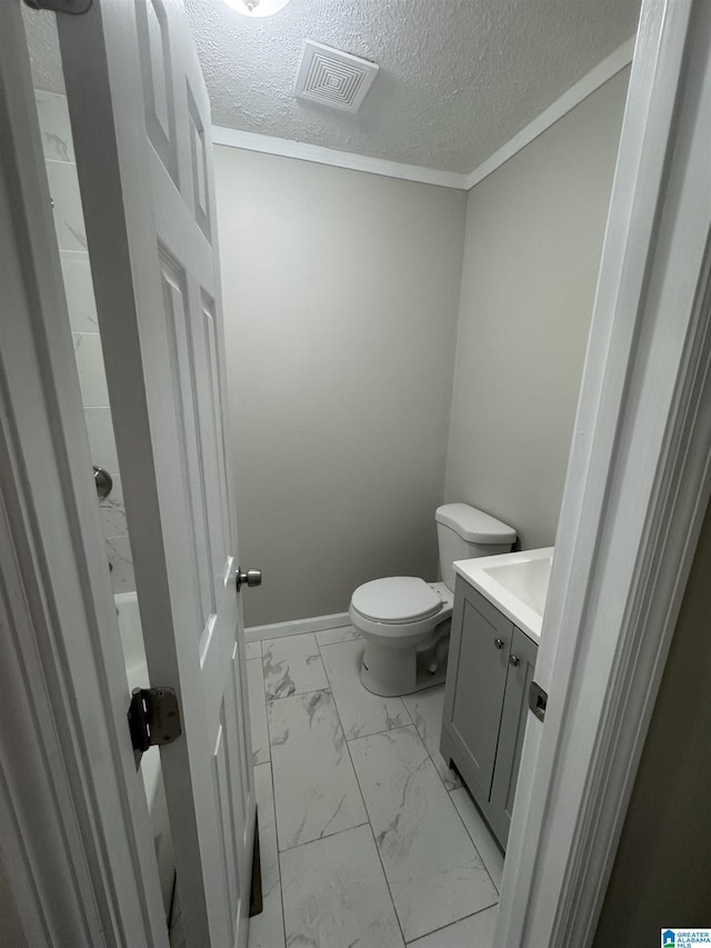 bathroom featuring vanity, visible vents, marble finish floor, toilet, and a textured ceiling