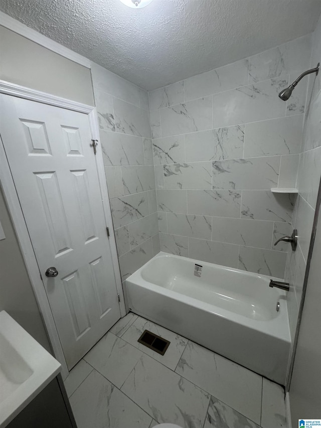 full bathroom with shower / washtub combination, a textured ceiling, and marble finish floor
