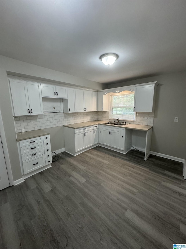 kitchen featuring a sink, tasteful backsplash, dark wood-style flooring, and white cabinetry