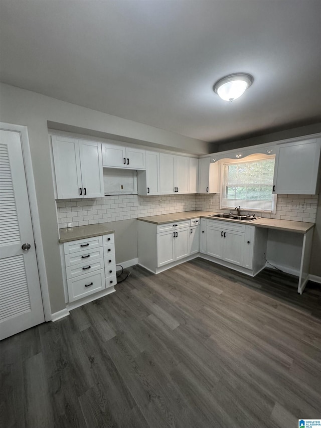 kitchen featuring dark wood-type flooring, a sink, white cabinets, and tasteful backsplash