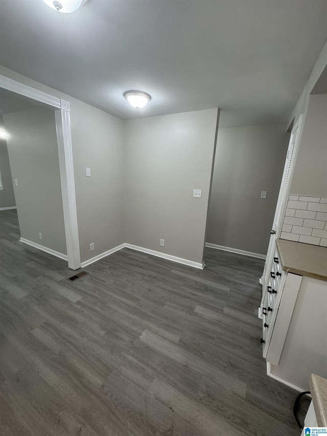 below grade area with baseboards and dark wood-style floors