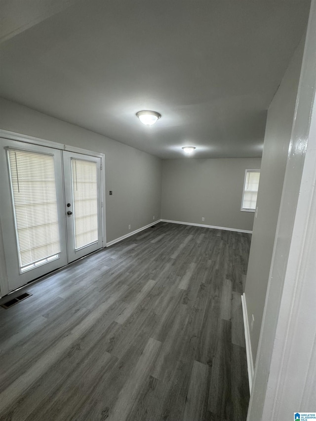 interior space with french doors, baseboards, wood finished floors, and visible vents