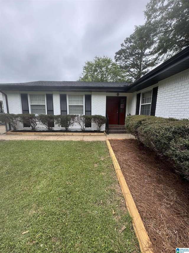 exterior space featuring brick siding and a lawn