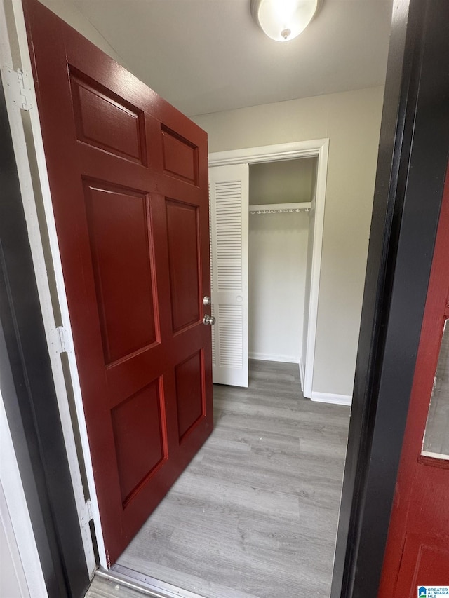 hall featuring baseboards and light wood-type flooring