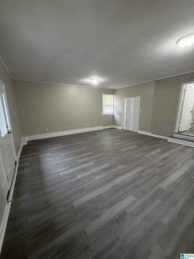basement with baseboards, a textured ceiling, and dark wood-style floors