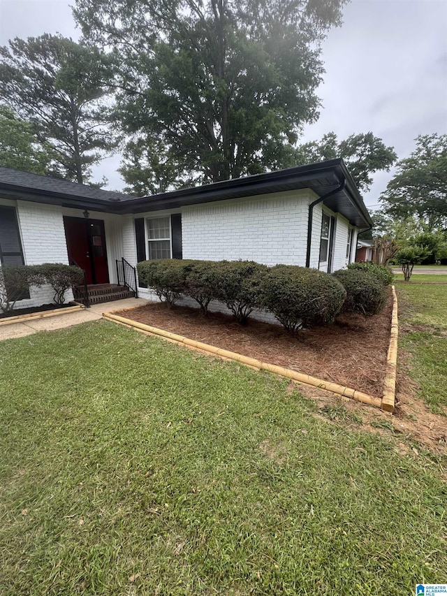 exterior space featuring a front yard and brick siding