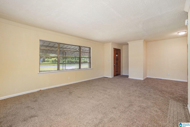 empty room with baseboards, a textured ceiling, and carpet