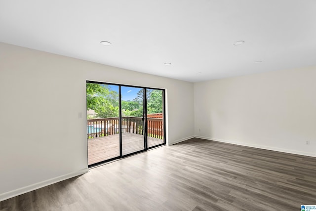 unfurnished room featuring recessed lighting, baseboards, and wood finished floors