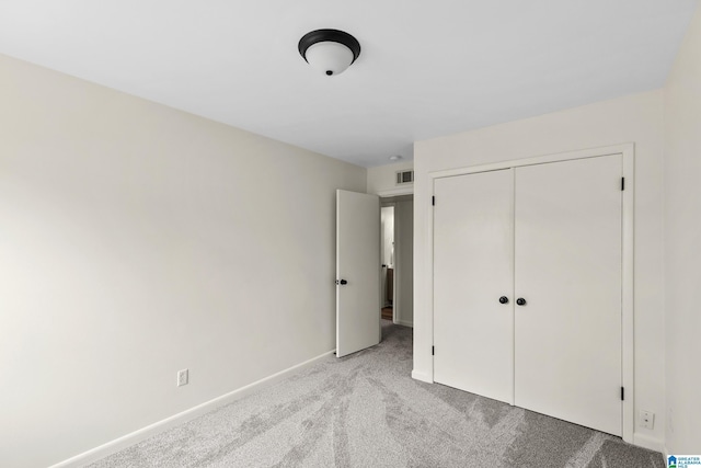 unfurnished bedroom featuring baseboards, visible vents, light carpet, and a closet