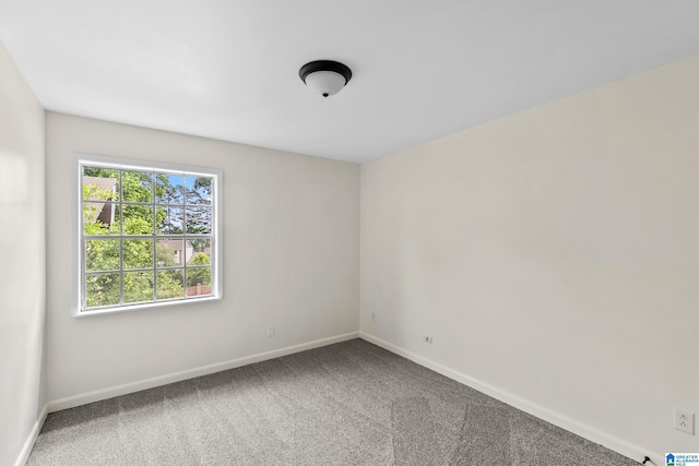 carpeted spare room featuring baseboards
