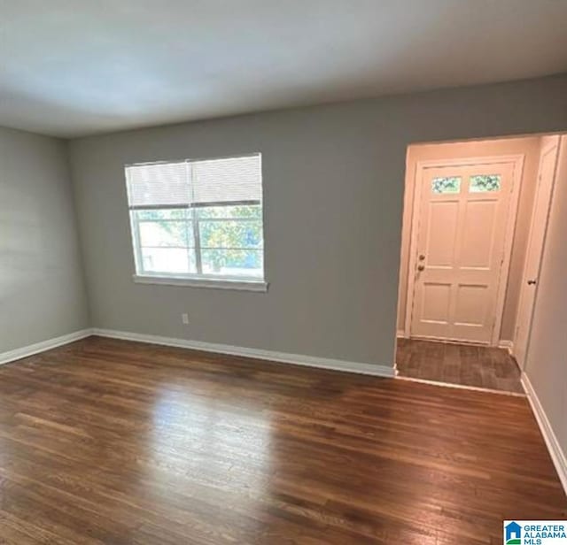 foyer entrance featuring baseboards and dark wood-type flooring