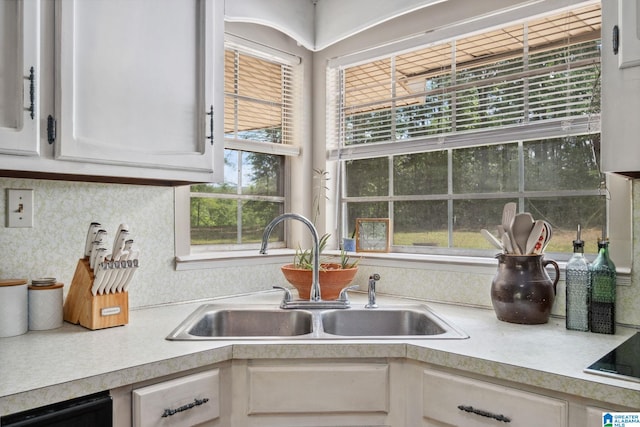 kitchen featuring a sink, white cabinets, and light countertops