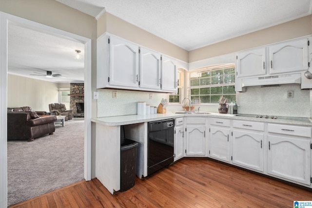kitchen with white cabinets, a sink, light countertops, under cabinet range hood, and black appliances