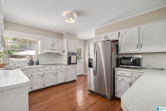 kitchen with a sink, black appliances, white cabinetry, and under cabinet range hood
