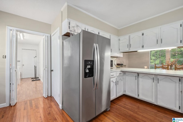 kitchen featuring light countertops, white cabinetry, stainless steel fridge, and wood finished floors