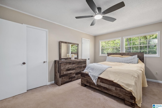 bedroom featuring light carpet, a ceiling fan, and a textured ceiling