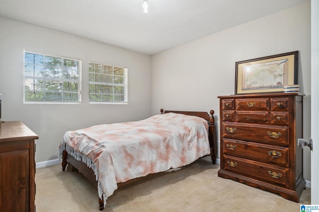 bedroom with baseboards and light colored carpet
