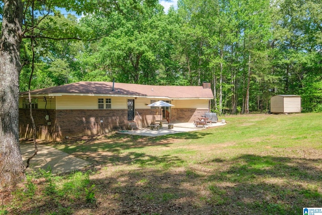 back of property with brick siding, a storage shed, a patio area, a lawn, and an outdoor structure