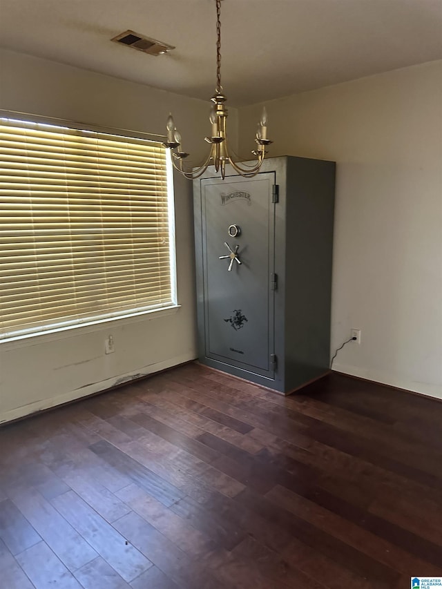 unfurnished dining area with visible vents, dark wood finished floors, and a chandelier
