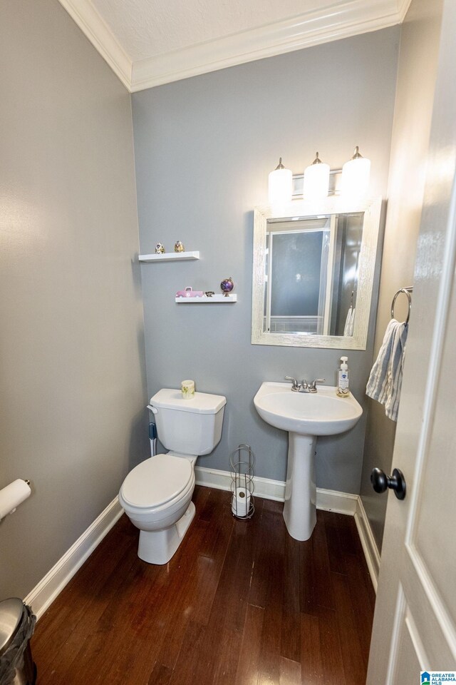 166 Hickory Ridge Dr, Glencoe, AL 35905 - half bathroom featuring wood finished floors, crown molding, baseboards, toilet, and a sink