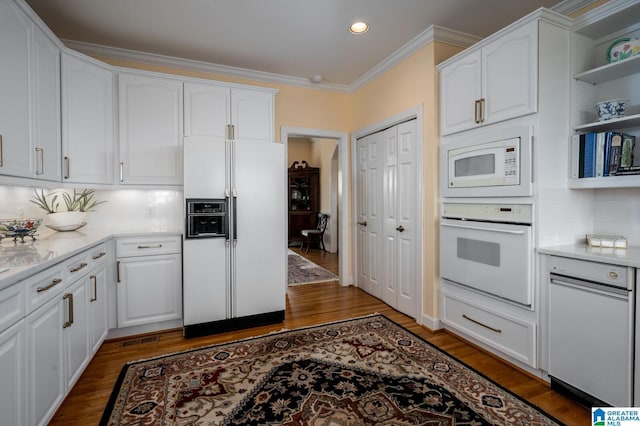 kitchen featuring white appliances, wood finished floors, recessed lighting, crown molding, and white cabinets