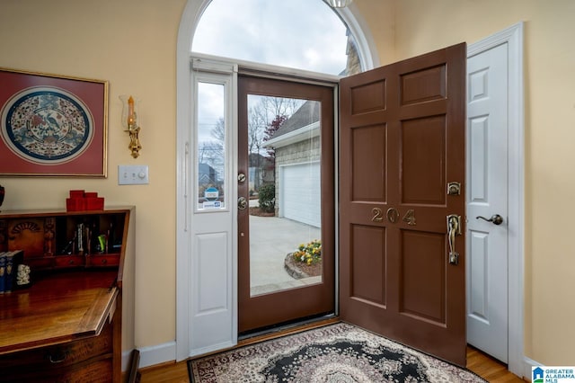 entrance foyer with baseboards, a wealth of natural light, and light wood-style floors