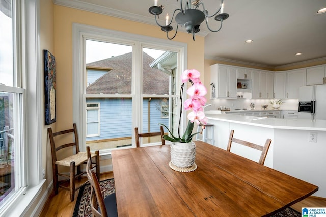 dining room featuring recessed lighting, a notable chandelier, crown molding, and wood finished floors