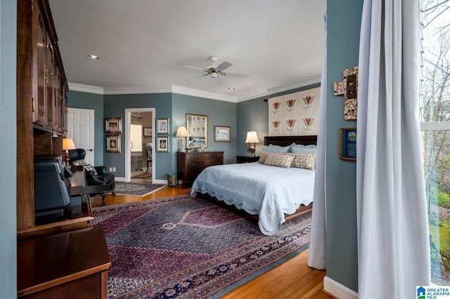 bedroom with crown molding, baseboards, and wood finished floors